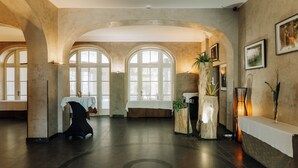 Un amplio vestíbulo con ventanales de arco, una recepción y un área de descanso.