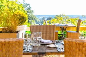 Enjoy a casual meal amidst lush greenery and distant hills.
