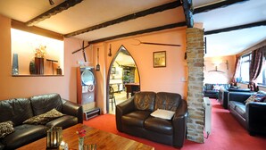 A cozy living room with a fireplace, leather sofas, and a wooden coffee table. - The West Country Inn (Bideford)