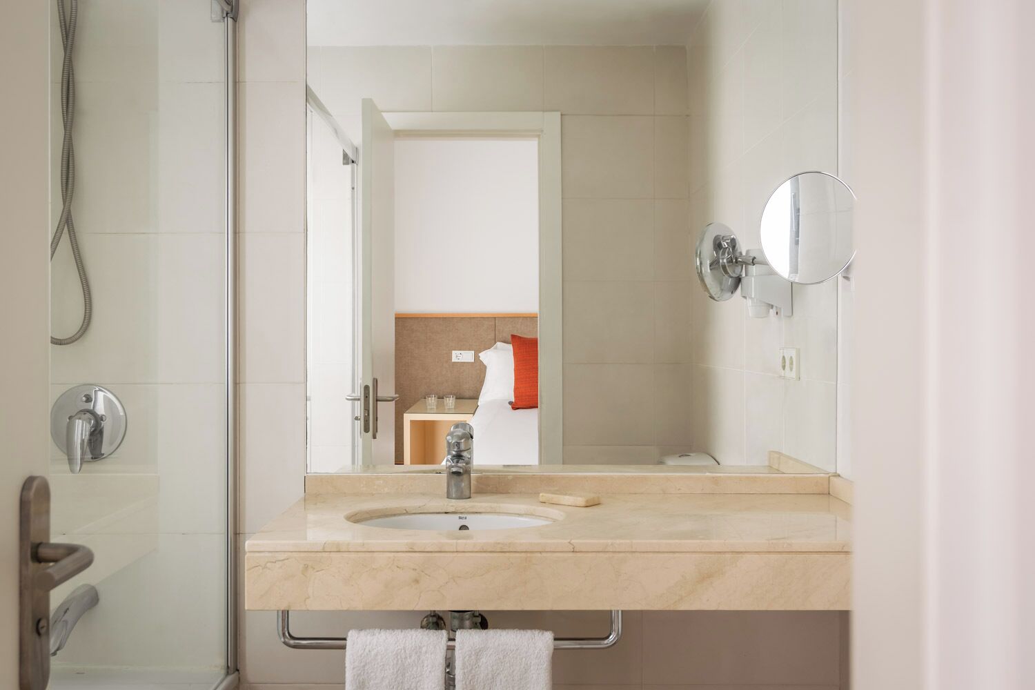 Un bagno moderno con uno specchio grande, un lavandino e una doccia.