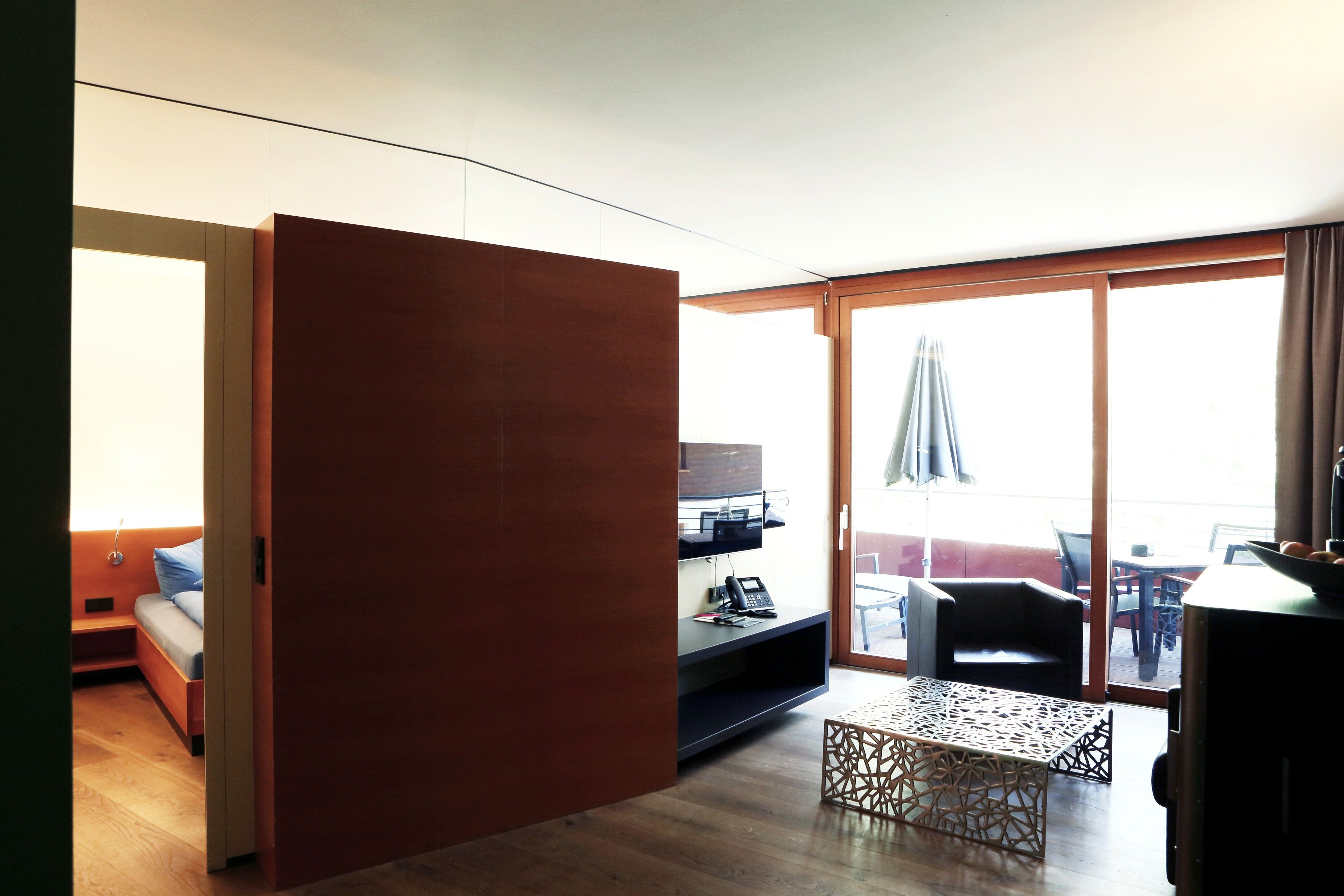 A modern living room with a sofa, a coffee table, and a desk with a computer.
