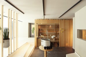 A modern kitchen with a wooden partition, a sink, and a stove.