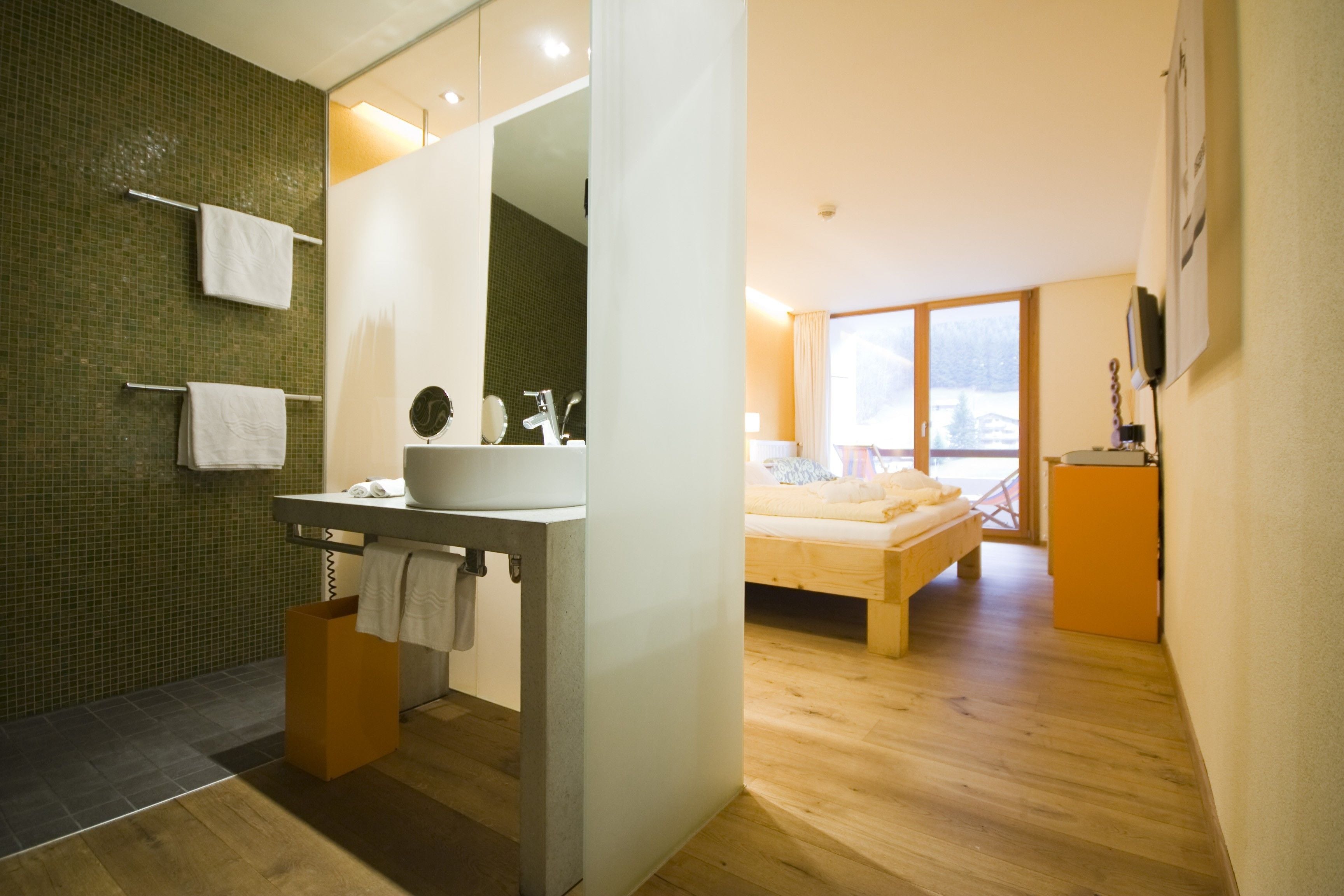 A modern bathroom with a large mirror, a sink, and a towel rack.