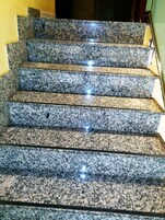 Un conjunto de escalones de granito con superficie reflectante.