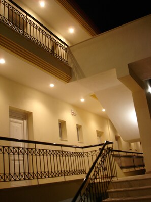 A multi-level building with a staircase and railing, featuring multiple windows and doors.
