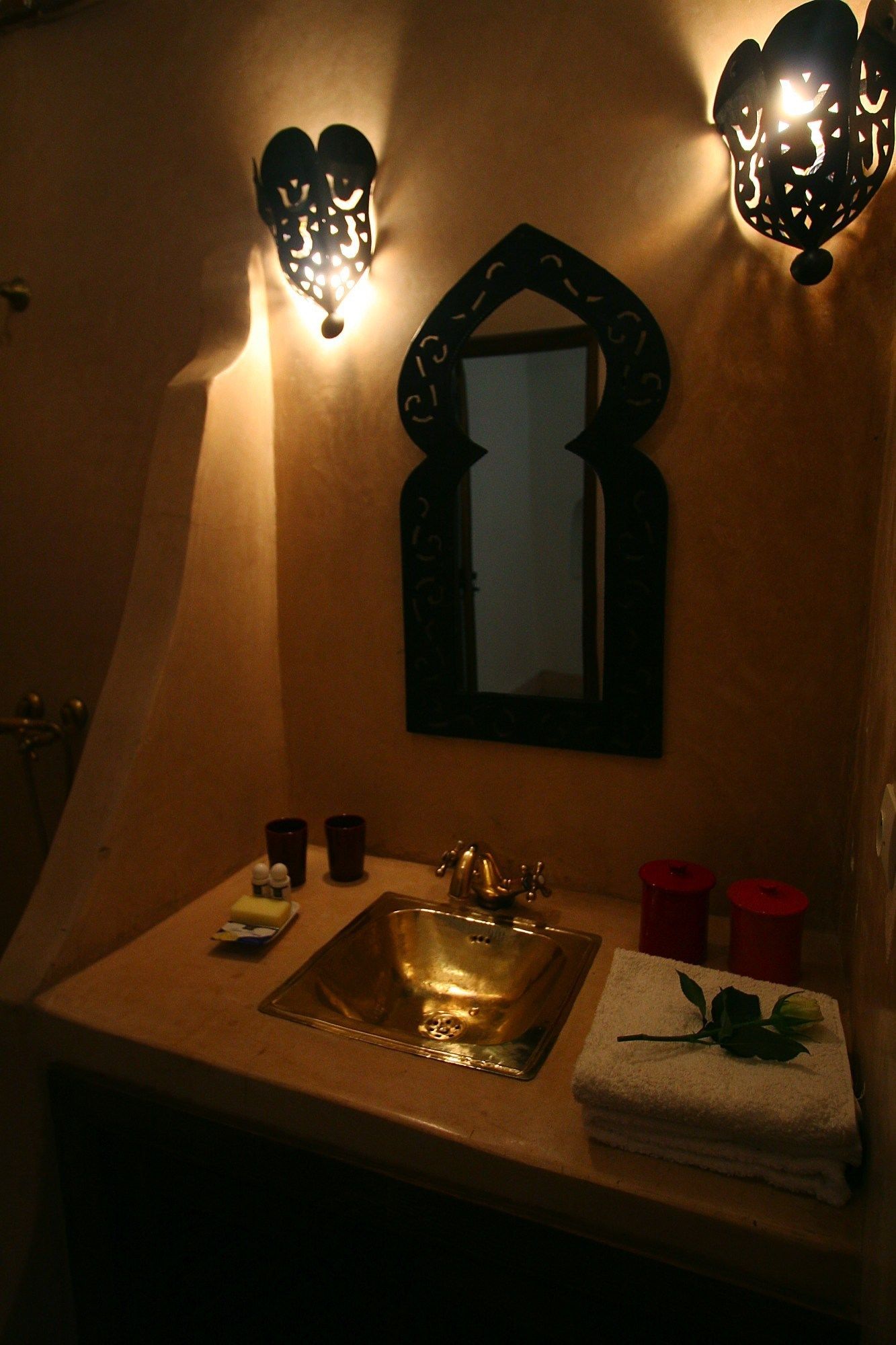 A bathroom with a sink, mirror, and two wall-mounted lights.
