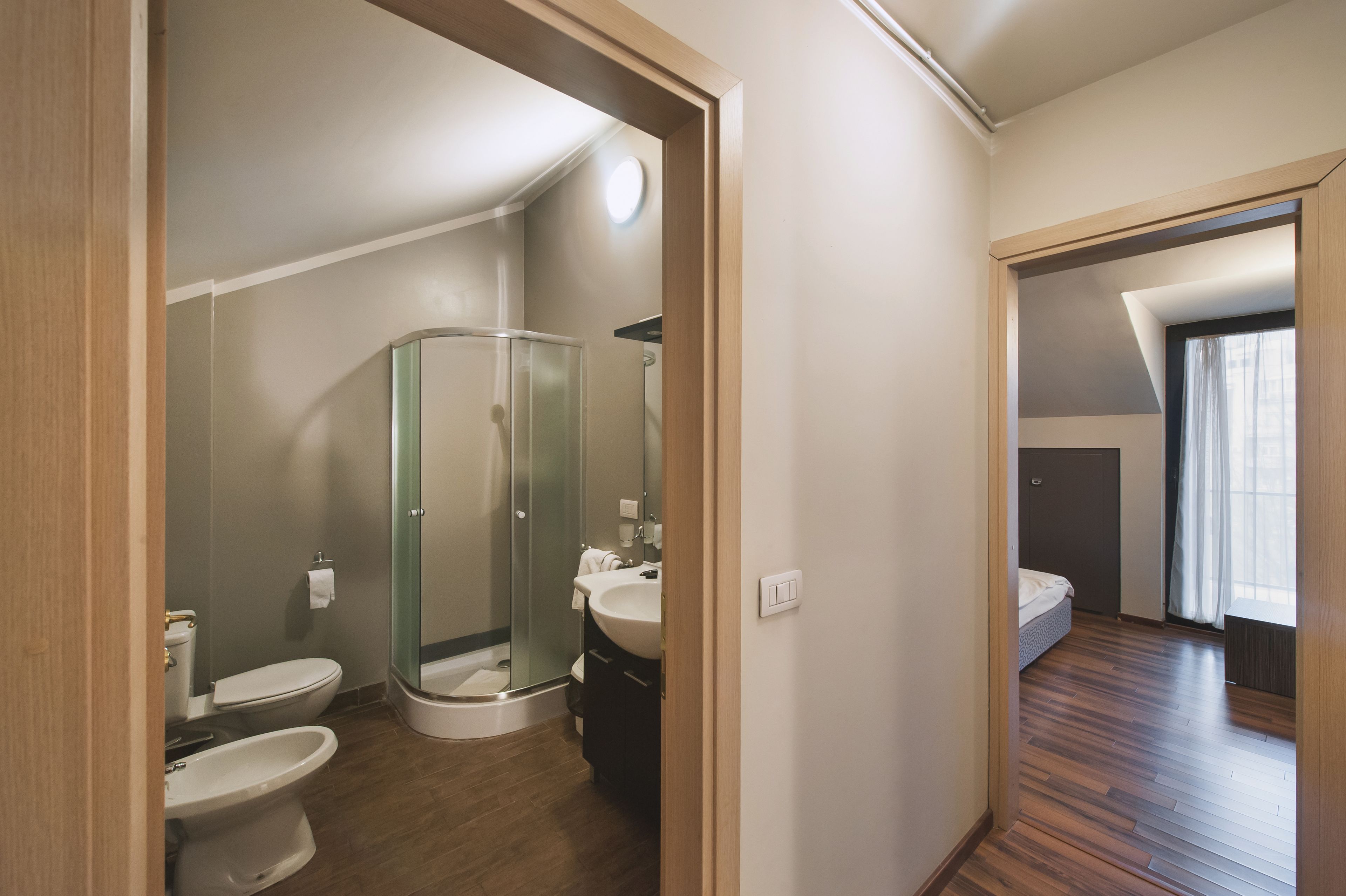 A modern bathroom with a glass shower enclosure, a toilet, and a sink.