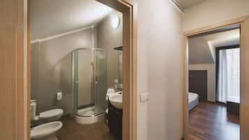 A modern bathroom with a glass shower enclosure, a toilet, and a sink.