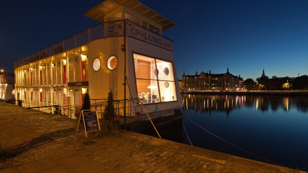 A waterfront hotel with a balcony, large windows, and a sign reading "CPHLIVING.com". - CPH Living (Copenhagen)