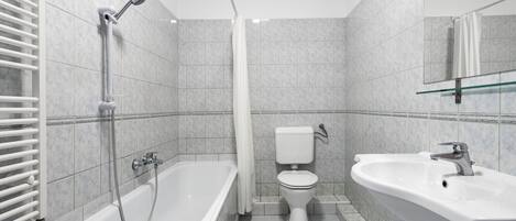 A modern bathroom with a bathtub, toilet, and sink.