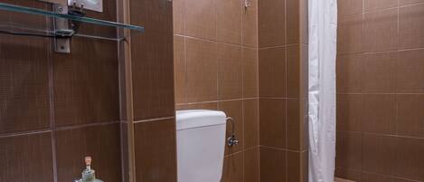 A bathroom with a toilet, sink, and shower.