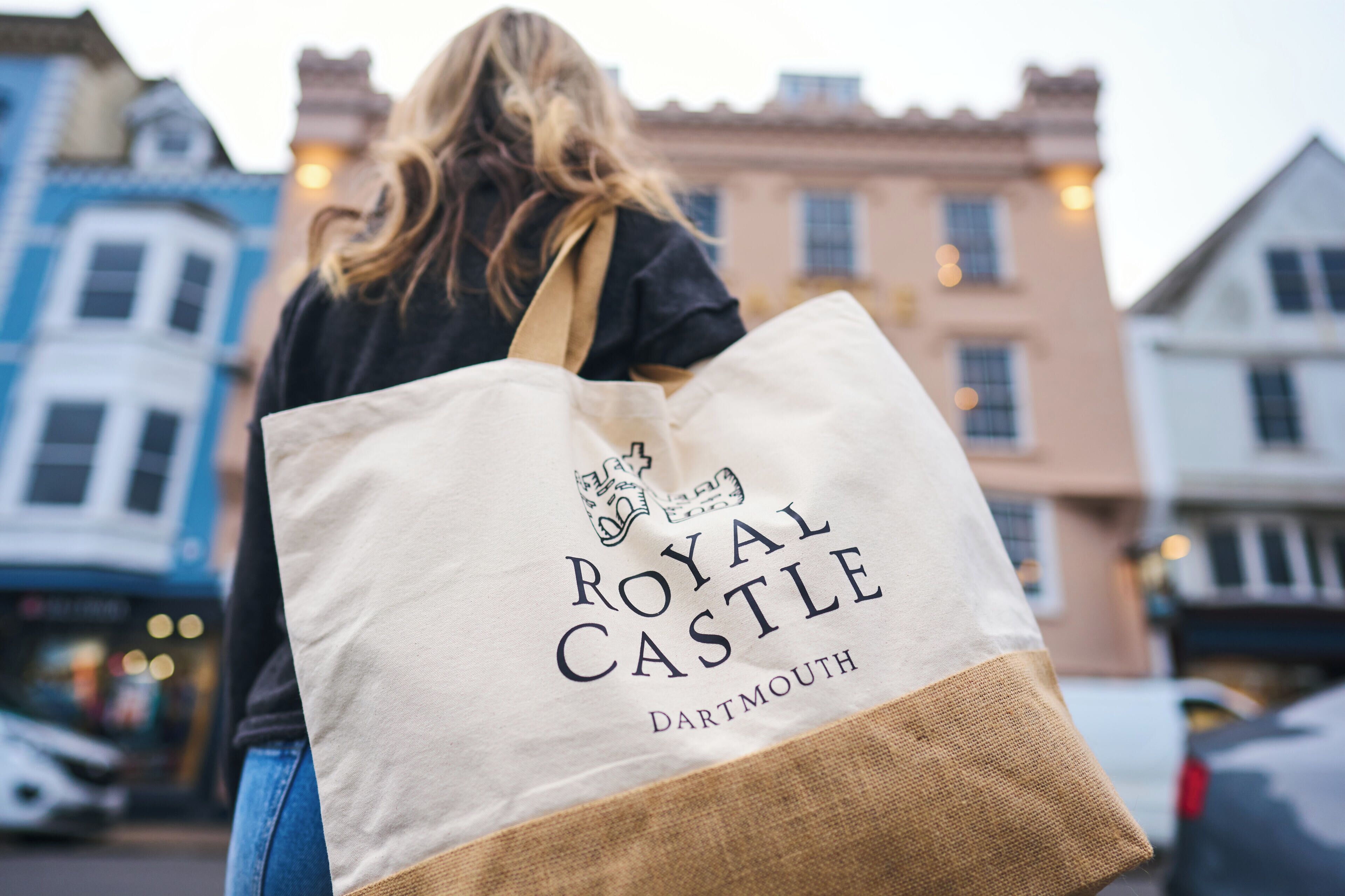 A person carrying a Royal Castle DARTMOUTH tote bag.