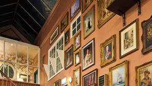 A multi-level interior with wooden staircases, numerous framed artworks, and a wall-mounted calendar. - Royal Castle Hotel (Dartmouth)