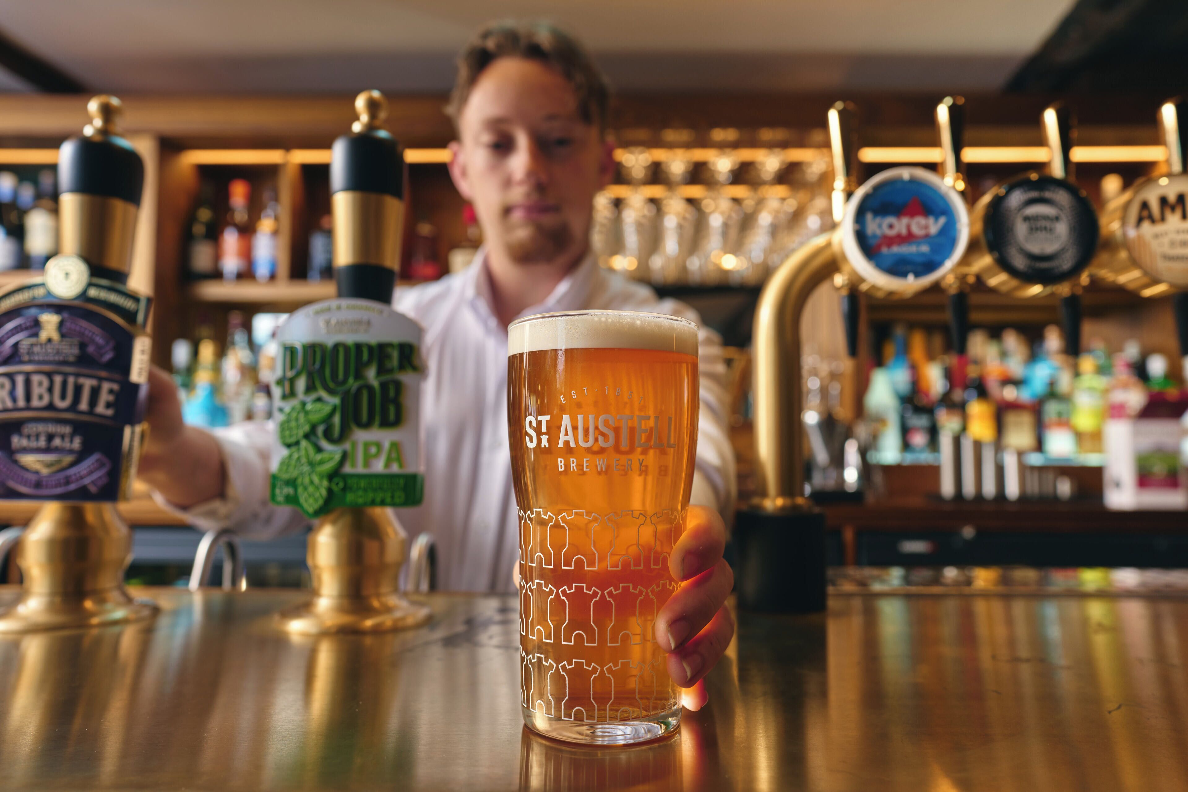 Un bar, avec un verre de bière posé devant le barman.
