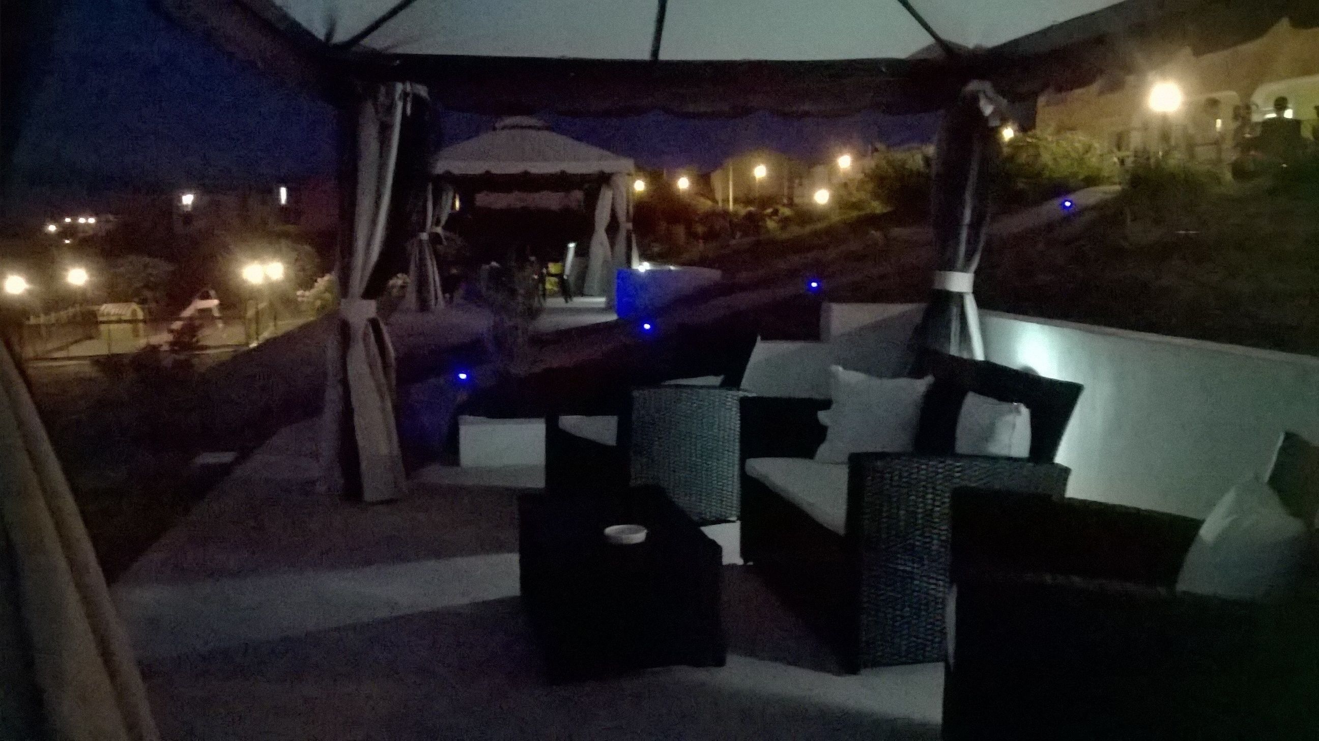 An outdoor seating area with wicker furniture and a canopy.