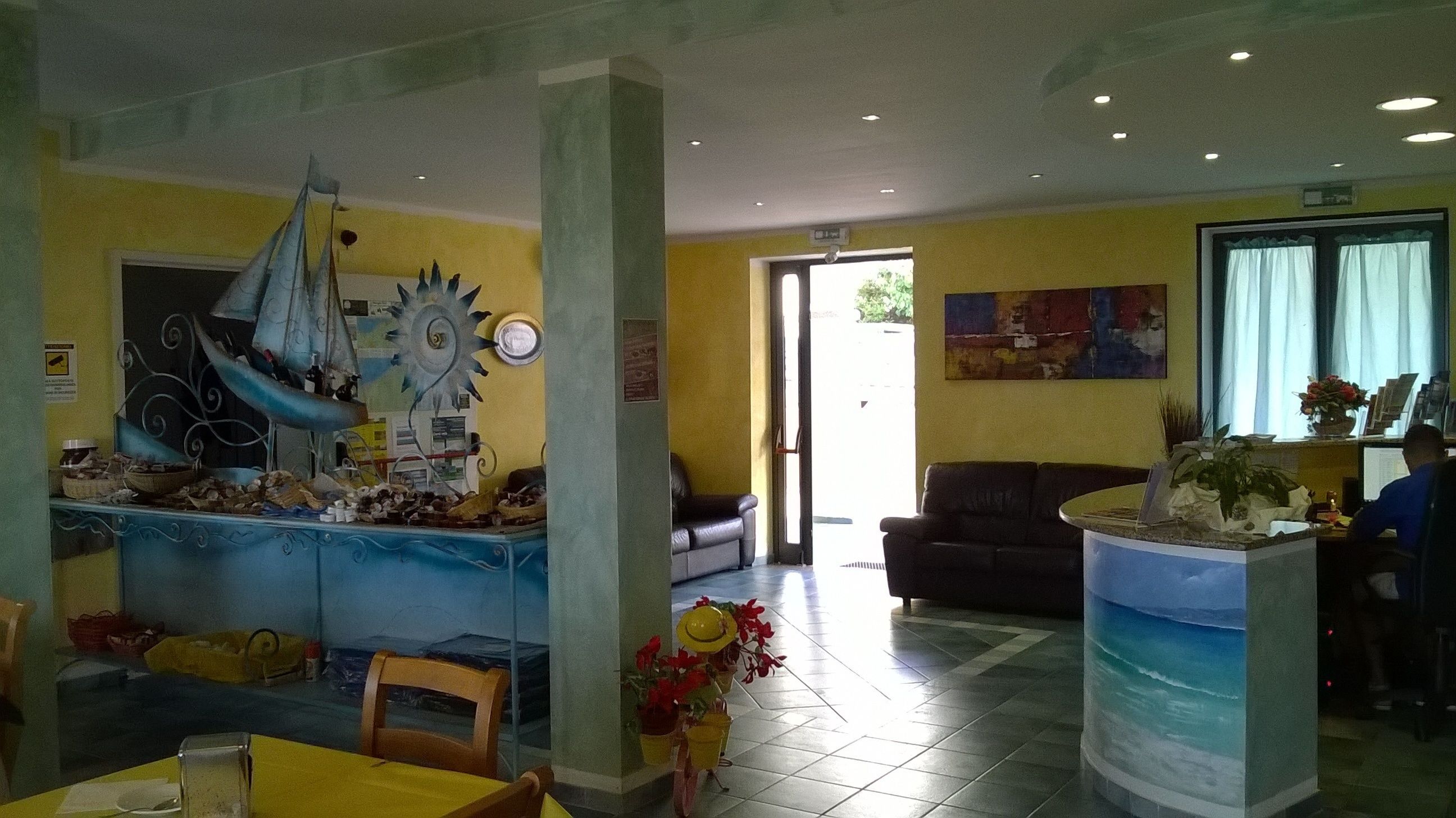 A dining area with a ship decoration, a sofa, and a fish tank.