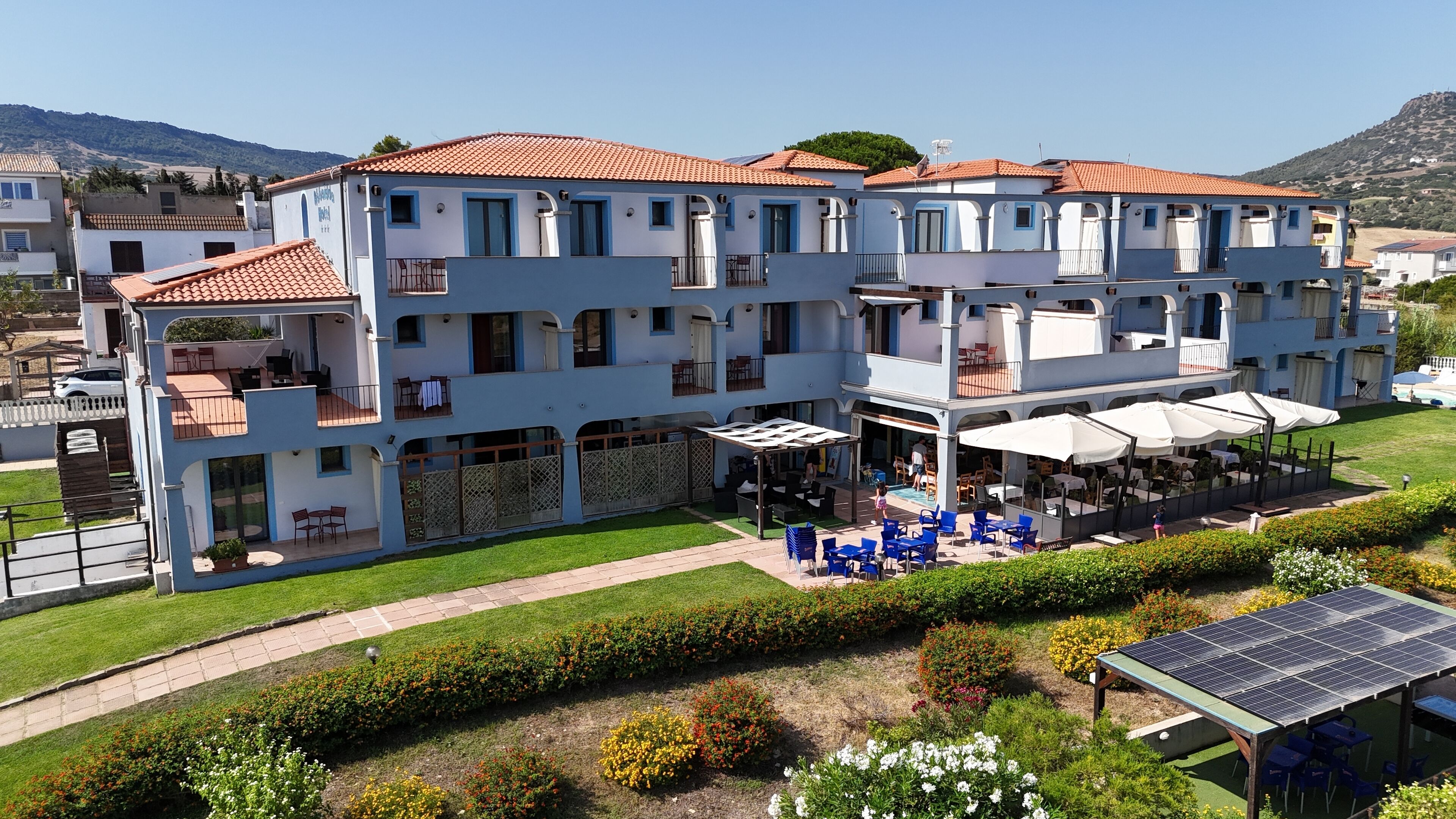 A multi-story hotel with outdoor seating and a pool.