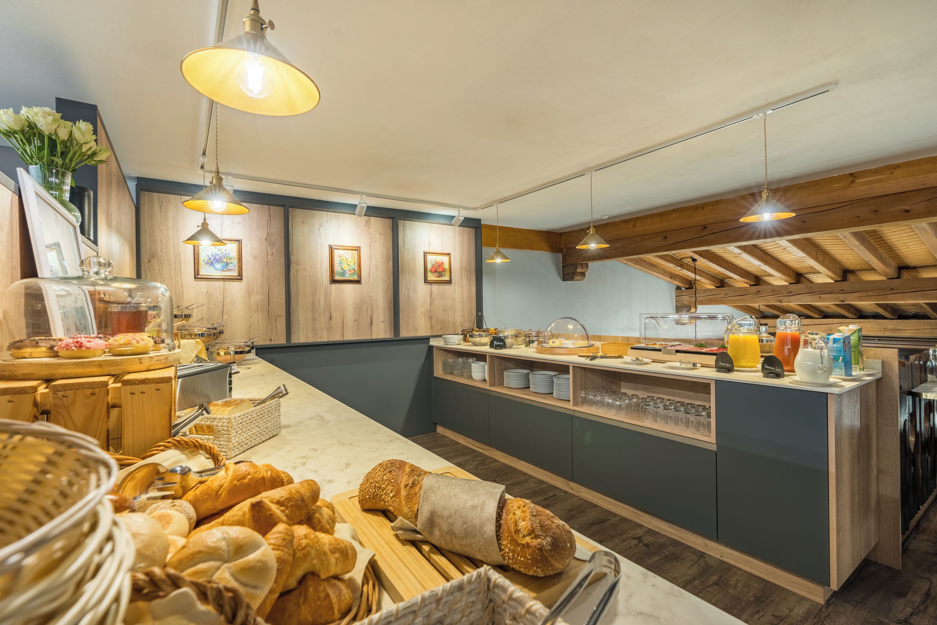 Ein reichhaltiges Frühstücksbuffet mit Brot, Gebäck und Getränken.
