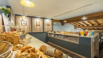 Ein reichhaltiges Frühstücksbuffet mit Brot, Gebäck und Getränken.