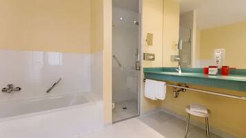 Ein modernes Badezimmer mit Badewanne, Dusche und Waschtisch mit Spiegel.