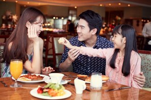 A dining area with a wooden table, plates of food, and a glass of orange juice. - Fairmont Yangcheng Lake (Suzhou)