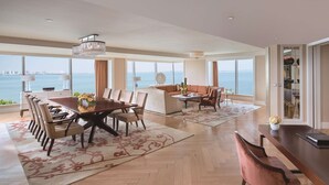 A spacious living area with a large dining table, comfortable seating, and a view of the sea. - Fairmont Yangcheng Lake (Suzhou)