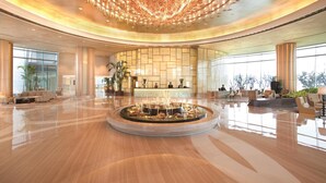 A spacious lobby with a central fountain, large windows, and a reception desk. - Fairmont Yangcheng Lake (Suzhou)
