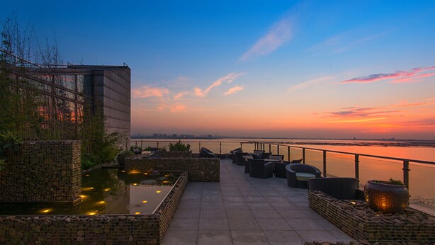A waterfront terrace with seating and a koi pond. - Fairmont Yangcheng Lake (Suzhou)