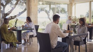A dining area with tables and chairs, large windows, and a view of the outdoors. - Hotel Resort Corte Di Ferro (Carovigno)