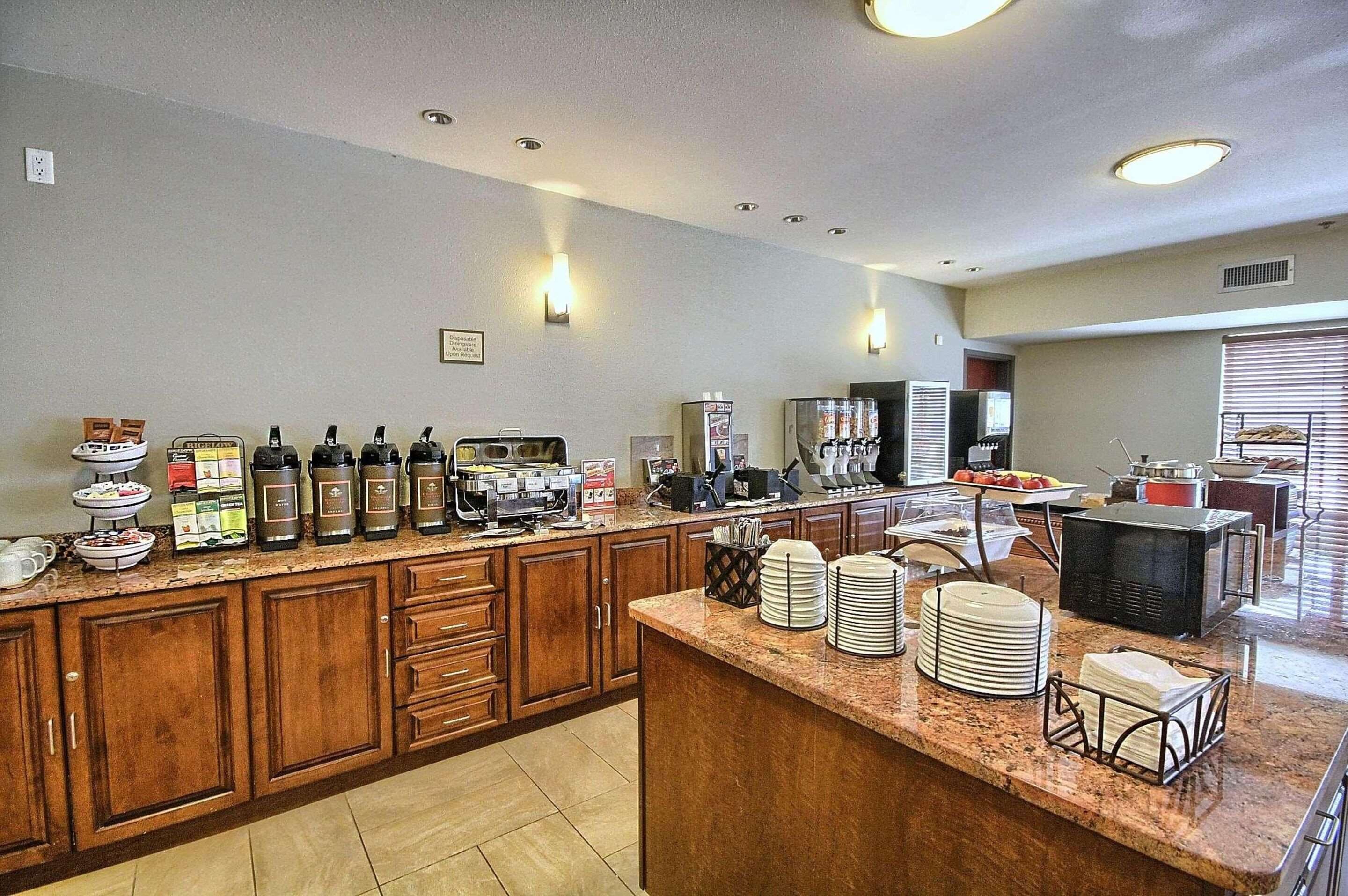 A hotel kitchen with a buffet setup, including various food items and beverages.