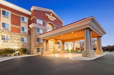 A Country Inn & Suites by Radisson building with a covered entrance and stone facade.