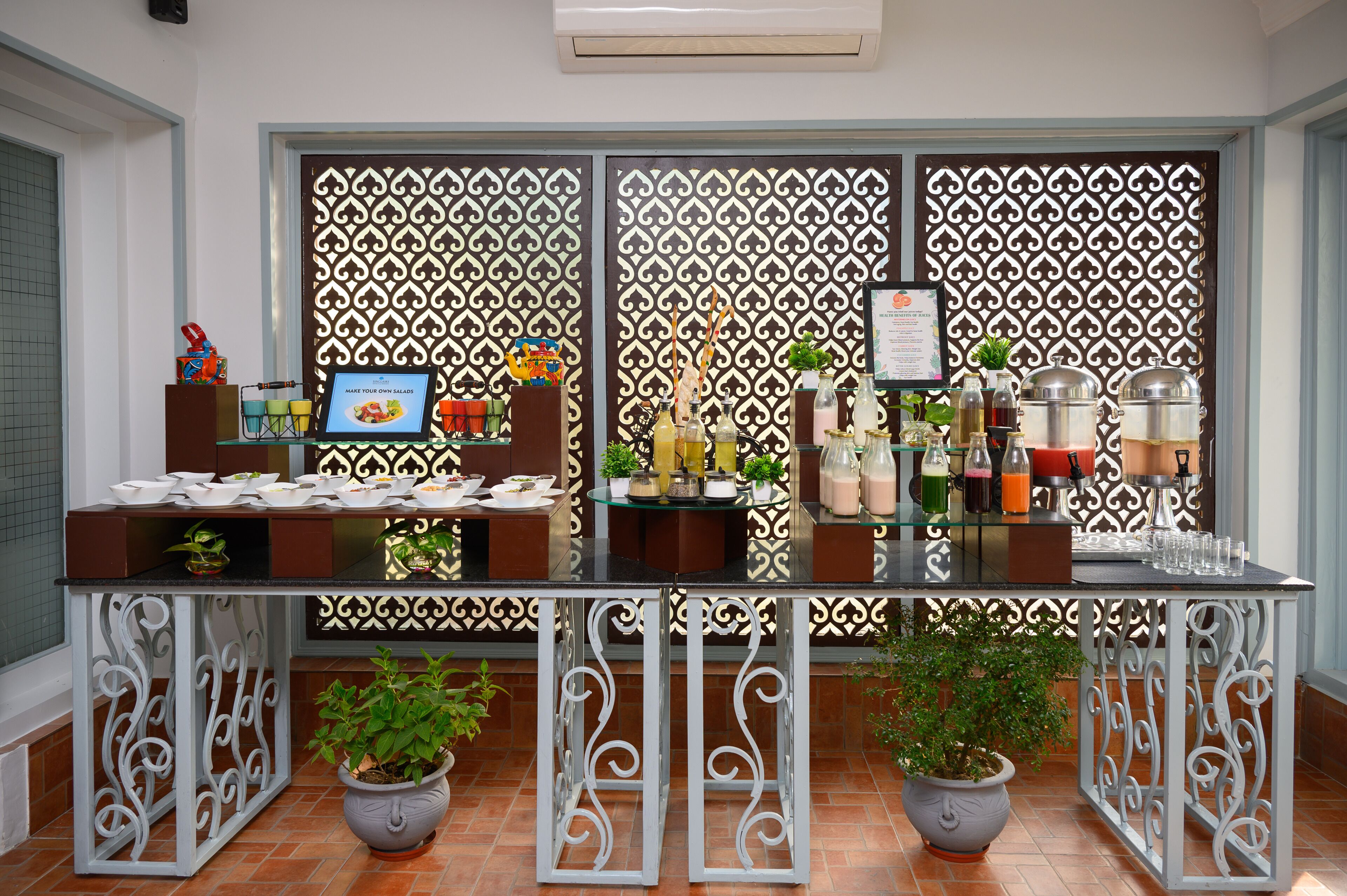 A buffet setup with a decorative backdrop, a menu board, and various food and drink containers.