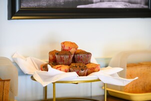 Una bandeja de muffins sobre una mesa, con un cuadro enmarcado al fondo.