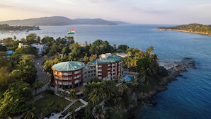 Hotel à beira-mar com vários edifícios, uma piscina e uma bandeira.