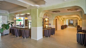 Eine Lobby mit Barbereich, Sitzgelegenheiten und einer Treppe.