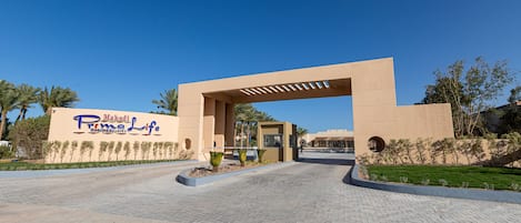 Ein Hotel Eingang mit einem großen Bogen und einem Schild für Makadi Roma Life Hotels & Resorts.