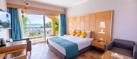 Une chambre d’hôtel avec un grand lit, un bureau, une chaise, une table de chevet et une vue sur l’extérieur.