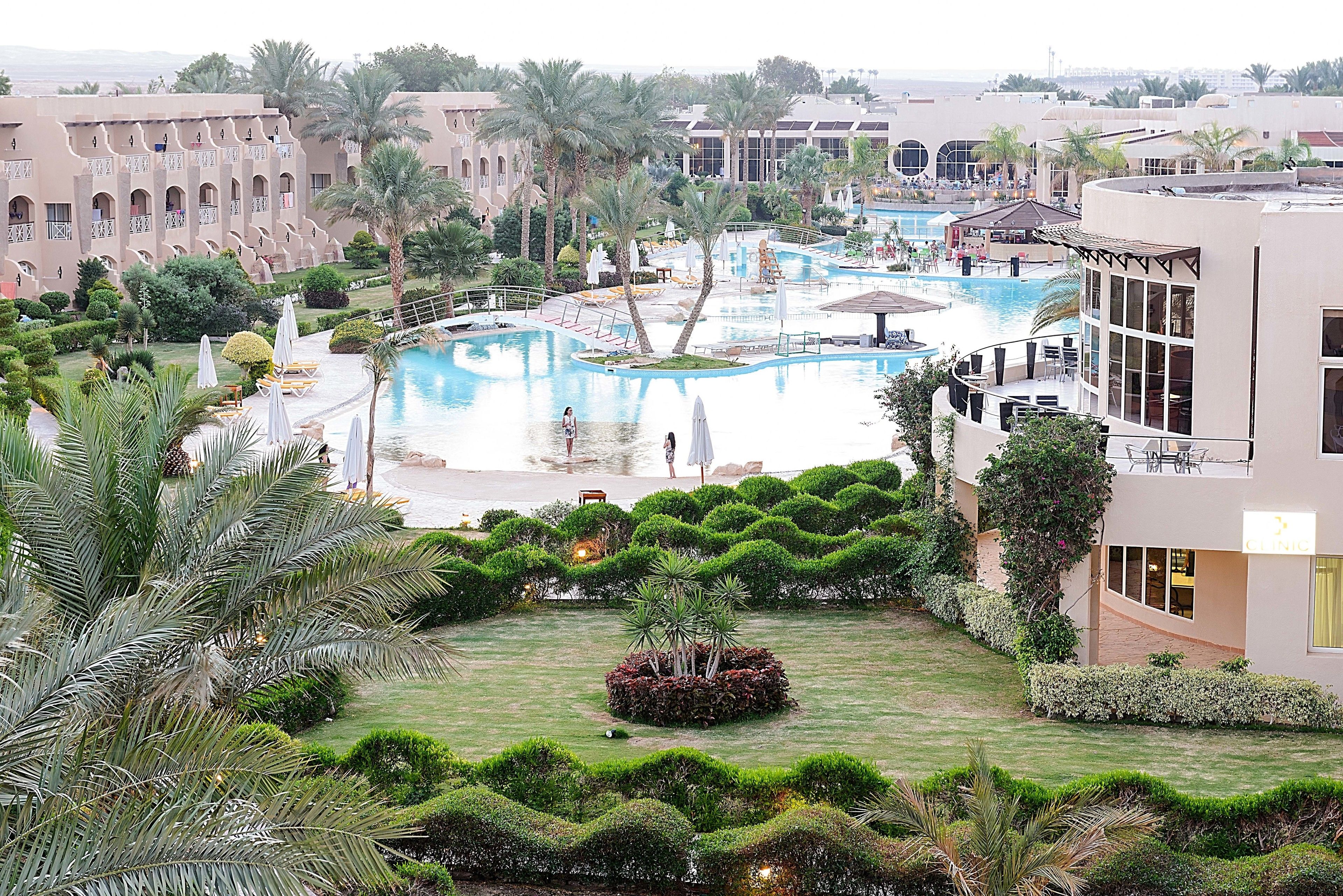 Un resort con múltiples piscinas, exuberante jardinería y arquitectura moderna.