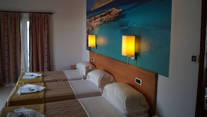 Habitación de hotel con una cama grande, dos mesitas de noche y un cuadro de una escena costera.