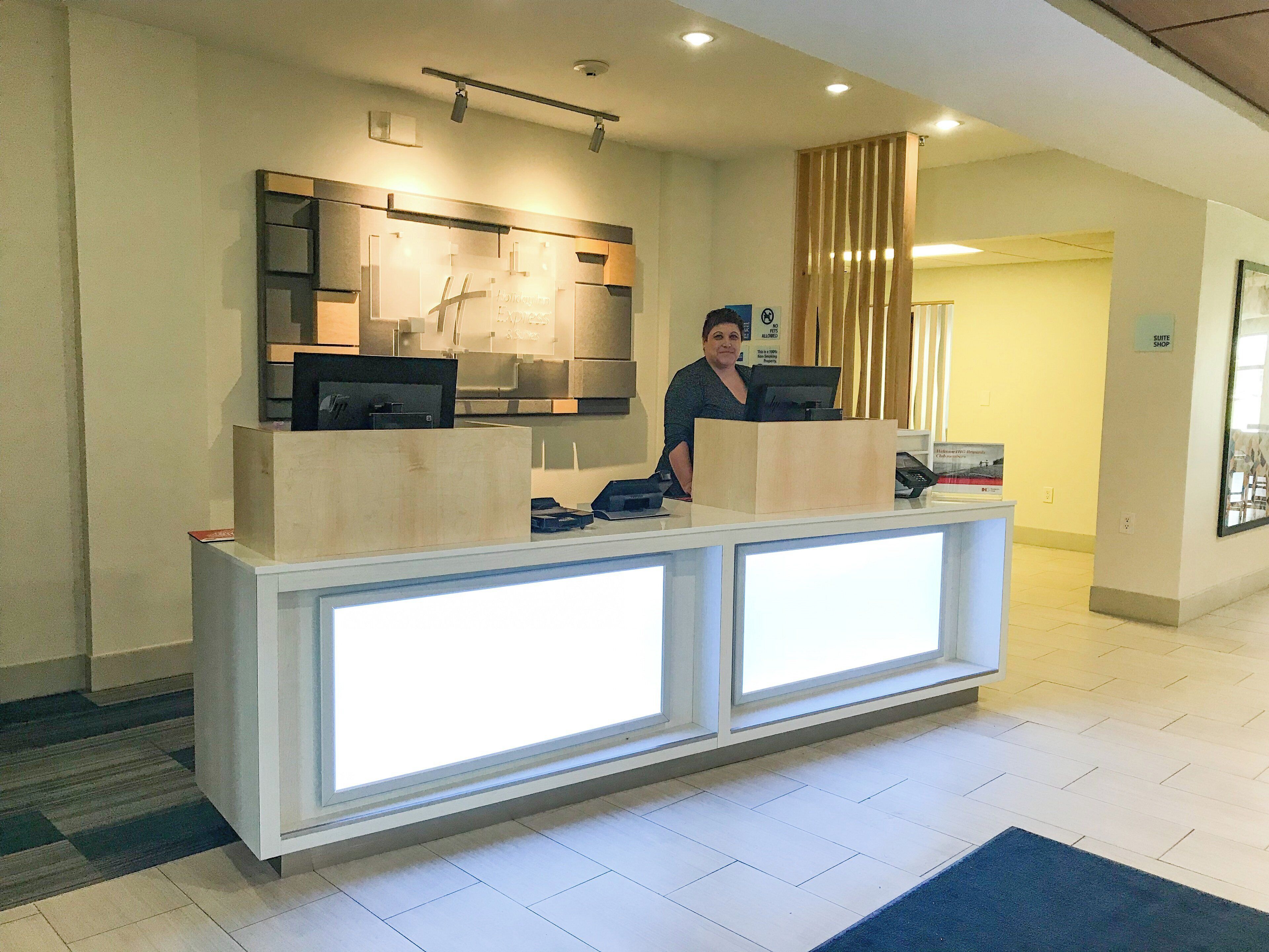 Een receptiebalie met een computer, telefoon en een bord waarop een suite shop wordt aangeduid.