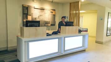 Una recepción con una computadora, un teléfono y un letrero que indica una tienda de suites.