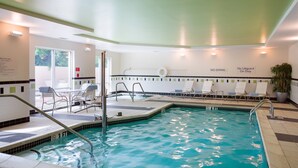 An indoor swimming pool with a 3ft depth limit, lounge chairs, and a sign indicating no diving or lifeguard on duty.