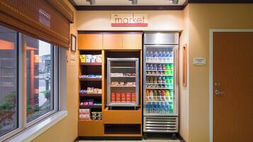 A small market area with refrigerated sections and shelves stocked with snacks and beverages.