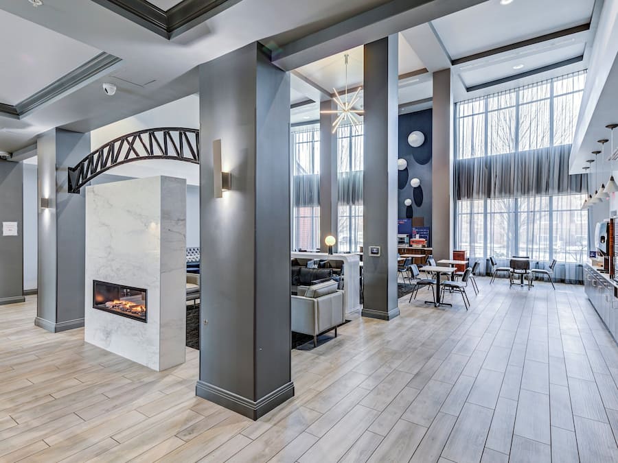 A spacious lobby with a fireplace, seating area, and large windows.
