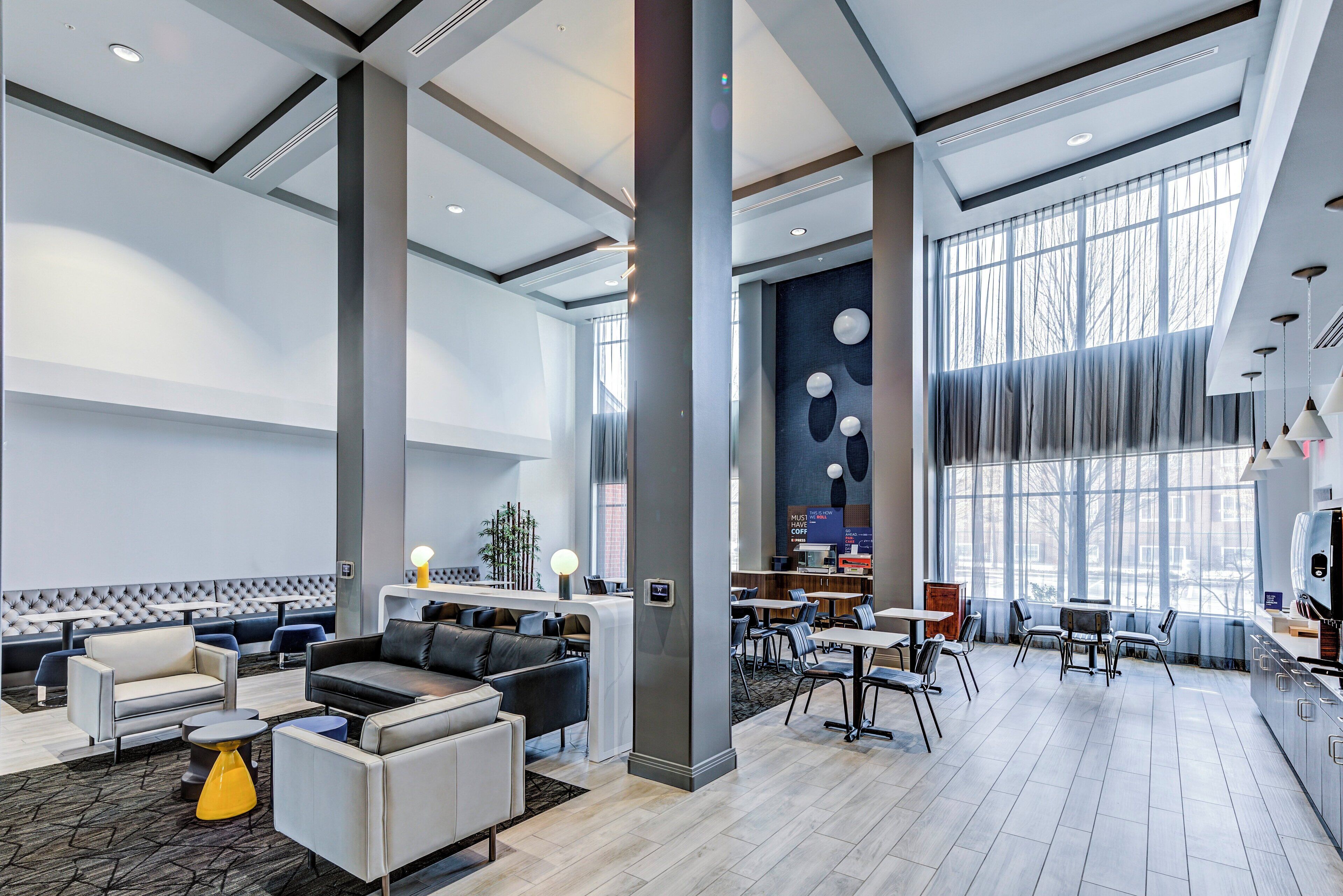A spacious lobby with seating areas, a reception desk, and large windows providing natural light.