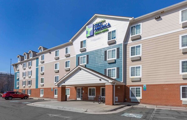 Un hôtel à plusieurs étages, avec une enseigne indiquant « Stay America Select Suites ».