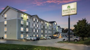Een meerhoog hotel met een bordje 'HomeTowe Studios by Red Roof' dat een bedrijfsruimte aangeeft.
