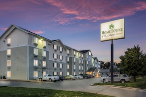 Et hotel i flere etager med et skilt for 'HomeTowe Studios by Red Roof', der angiver et forretningscenter.