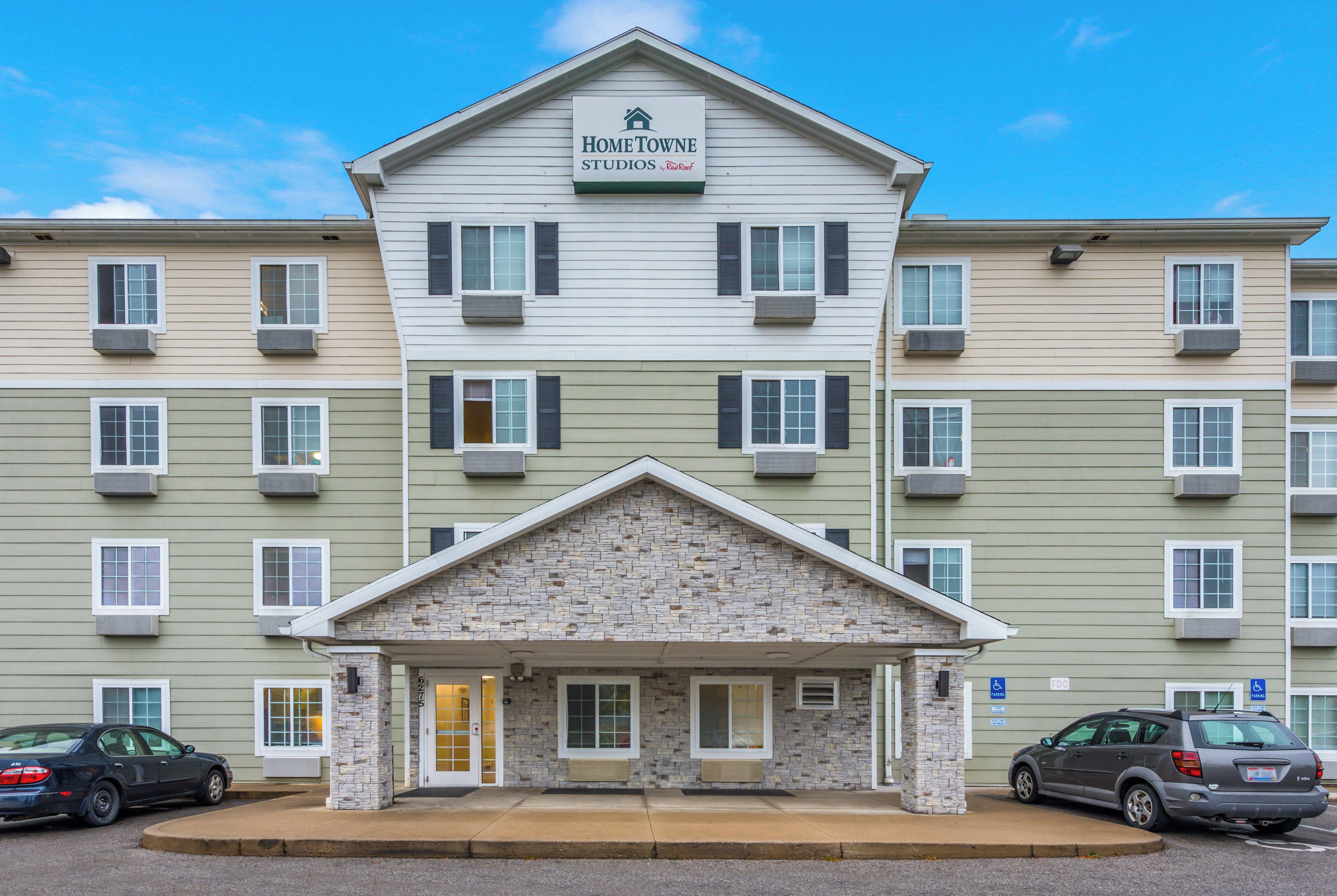 A multi-story building with a sign reading 'HomeTown Studios by RedRoof.'