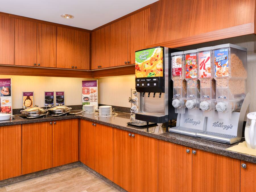 Een ontbijtbalk met een koffieapparaat, een cornflakesautomaat en diverse ontbijtartikelen.